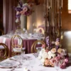 Złoty Kandelabr Glamour. Urokliwa aranżacja stołu weselnego z rent4events.pl, z centralnie umieszczonym złotym kandelabrem glamour, otoczonym przez kompozycje kwiatowe w odcieniach różu i fioletu. Złote krzesła i eleganckie nakrycia stołu dopełniają romantycznego i glamour stylu uroczystości. Ta prestiżowa dekoracja jest idealna do akcentowania wyjątkowej atmosfery wesel we Wrocławiu i okolicach - rent4events.pl wypożycz wrażenia, rent4wedding.pl zachowaj wspomnienia. Fot. BUCHOLCe @bucholce.