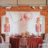 Dekoracja świąteczna na eventy, wesela i śluby w Wrocławiu od rent4events.pl. Eleganckie tło z napisem "Merry Christmas" w odcieniach różu i bieli, otoczone figurkami różowych Dziadków do Orzechów. Stół z bordowym obrusem, ozdobami świątecznymi, różowymi kieliszkami i elegancką zastawą. Przezroczyste krzesła Ghost dodają nowoczesnego charakteru. Idealna scenografia na wyjątkowe okazje - rent4events.pl wypożycz wrażenia, rent4weddings.pl zachowaj wspomnienia. Fot. @karolinakiec_fotografia.