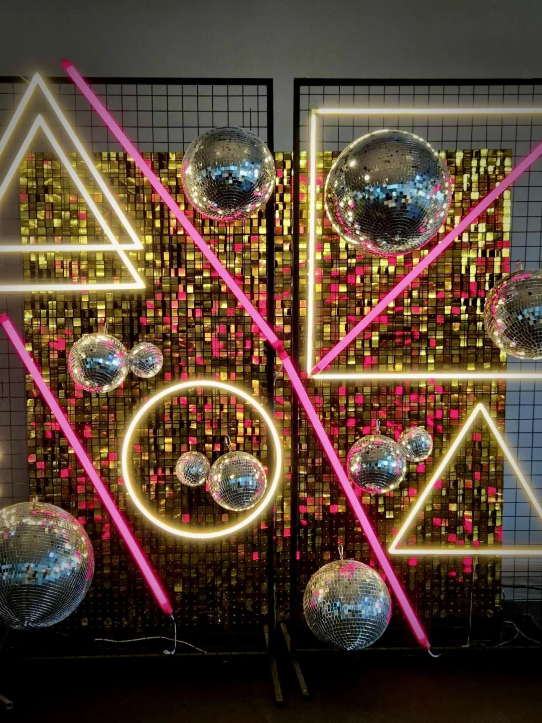 Oryginalna dekoracja w stylu disco z geometrycznym tłem, srebrnymi kulami lustrzanymi i neonowymi akcentami. Ścianka w stylu lat 70. i 80. doskonale sprawdzi się na eventy tematyczne, wesela lub sesje fotograficzne. Odbijające światło kule i złote akcenty dodają dynamiki i luksusu aranżacji. Wypożycz tę niepowtarzalną dekorację w Wrocławiu na rent4events.pl i rent4weddings.pl, by nadać swojemu wydarzeniu niezapomnianego blasku! - rent4events.pl – wypożycz wrażenia, rent4weddings.pl – zachowaj wspomnienia.