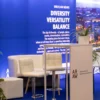 Nowoczesna przestrzeń eventowa zaprojektowana w stylu biznesowym z dominującym niebieskim tłem i napisem „Wrocław Means Diversity, Versatility, Balance”. W centrum znajduje się elegancka, biała strefa powitalna z wysokim stolikiem i wygodnymi hokerami o chromowanych podstawach, podkreślających minimalistyczny design. Z tyłu widoczna biała sofa strefy wypoczynkowej. Scenografia idealna na wydarzenia biznesowe, konferencje i eventy promujące Wrocław. Dekoracje i wyposażenie dostępne w Rent4Events - rent4events.pl wypożycz wrażenia, rent4weddings.pl zachowaj wspomnienia. Fot. @karolinakiec_fotografia.
