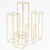 Zestaw złotych stojaków dekoracyjnych o wysokościach 30 cm, 40 cm, 65 cm i 85 cm. Geometryczne kształty i elegancki design sprawiają, że są idealne na stoły oraz jako ozdoba przestrzeni podczas ślubów, wesel i eventów. Styl glamour i złoty kolor świetnie współgrają z różnorodnymi aranżacjami. Doskonałe do tworzenia scenografii oraz ekskluzywnych dekoracji. Wypożyczalnia dekoracji Wrocław – rent4events.pl i rent4weddings.pl - rent4events.pl wypożycz wrażenia, rent4weddings.pl zachowaj wspomnienia.