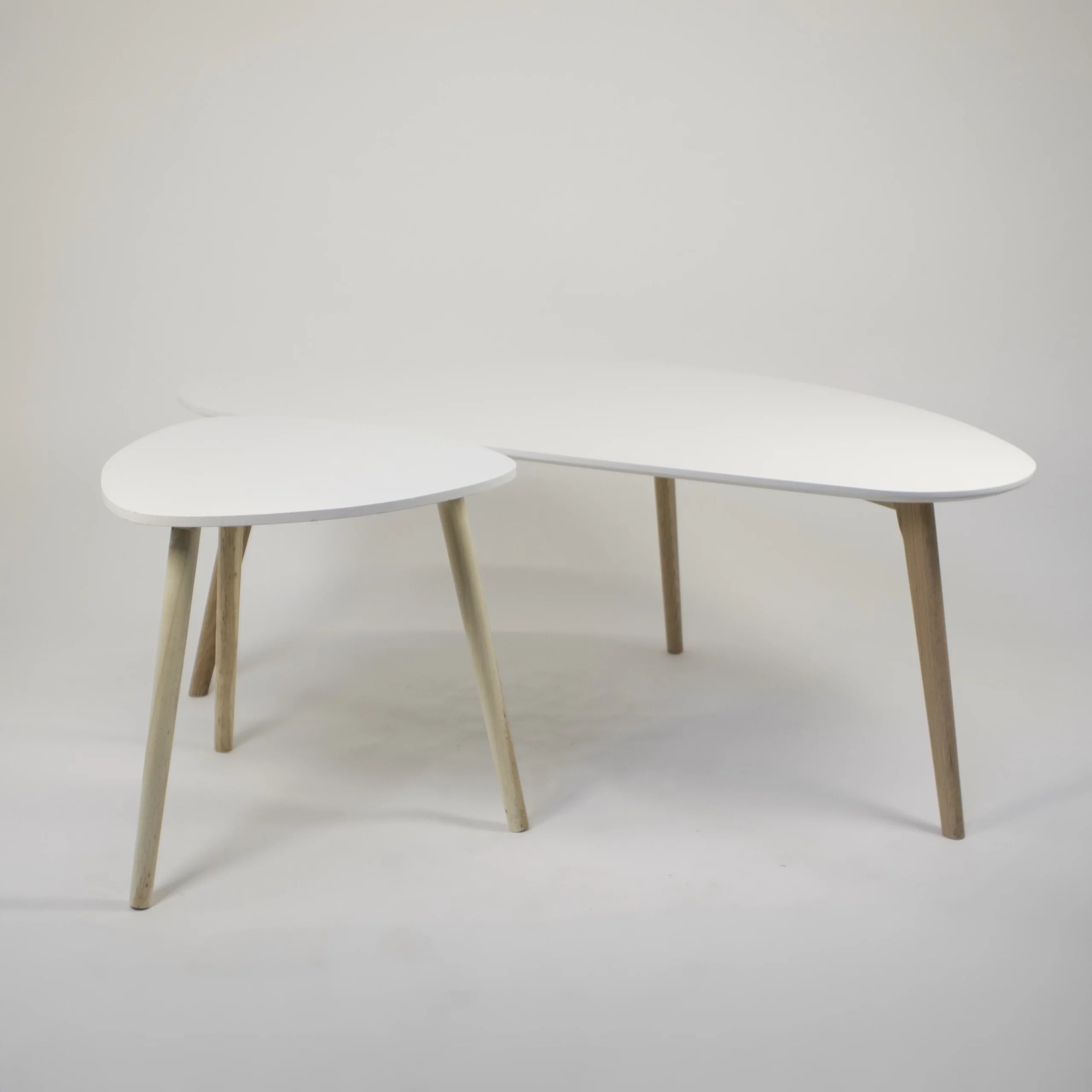 MST53a dwa stoliki kawowe trojkatny i nerka biale blaty styl skandynawski wesela eventy wypozyczalnia dekoracji rent4events rent4wedding wroclaw scaled - Wypożyczalnia Ślubna Zestaw dwóch stolików w różnych rozmiarach, wykonanych w skandynawskim stylu. Stoliki mają białe, zaokrąglone blaty oraz drewniane nogi, co nadaje im minimalistyczny i elegancki wygląd. Idealne jako elementy strefy wypoczynkowej czy kawowej na ślub, wesele lub eventy we Wrocławiu i okolicach. Funkcjonalne i estetyczne, świetnie wpisują się w nowoczesną scenografię. Oferowane przez wypożyczalnię Rent4Events, marki rent4events.pl i rent4weddings.pl - rent4events.pl wypożycz wrażenia, rent4weddings.pl zachowaj wspomnienia.