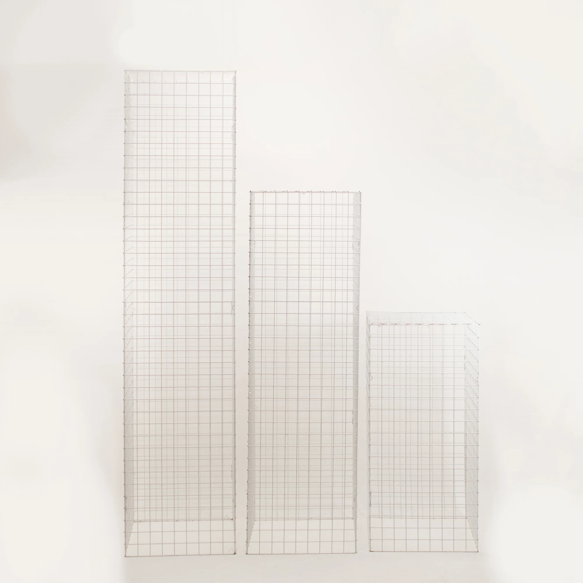 SST61i62i63 trzy biale slupki z kratki metalowe wesela eventy wypozyczalnia dekoracji rent4events wroclaw - Wypożyczalnia Ślubna Zestaw trzech białych słupków z kratki o wysokościach 95, 150 i 200 cm to nowoczesne elementy dekoracji scenograficznej, dostępne w wypożyczalni Rent4Events i Rent4Wedding we Wrocławiu. Konstrukcja z metalowej siatki tworzy przestrzenną formę, którą można dowolnie aranżować – jako ekspozytor, podest pod kwiaty, dekoracje lub branding. Świetnie sprawdzi się podczas organizacji ślubu, wesela lub eleganckiego eventu. Modułowy charakter pozwala na stworzenie efektownej, wielopoziomowej scenografii. Produkt dostępny w ofercie rent4events.pl oraz rent4weddings.pl - rent4events.pl wypożycz wrażenia, rent4wedding.pl zachowaj wspomnienia.